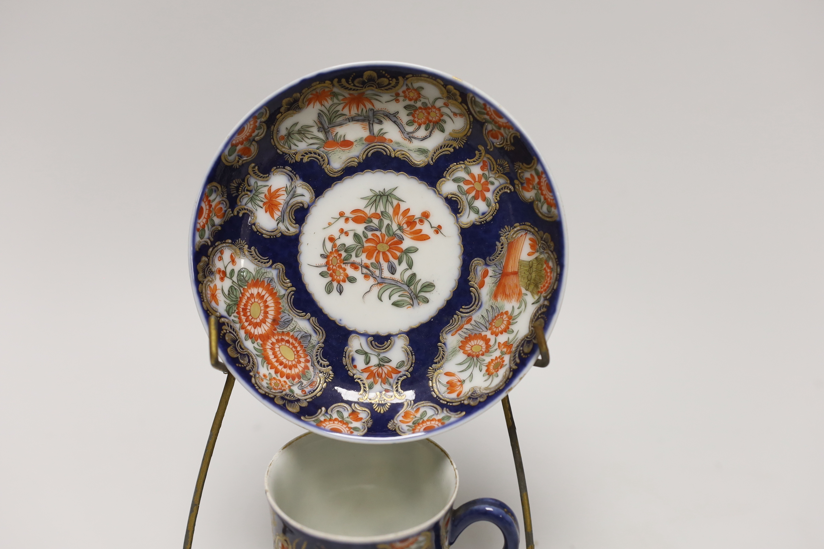 A Samson replica of a Worcester scale blue cup and saucer, hand painted with flowers on stand, the saucer 12cm in diameter